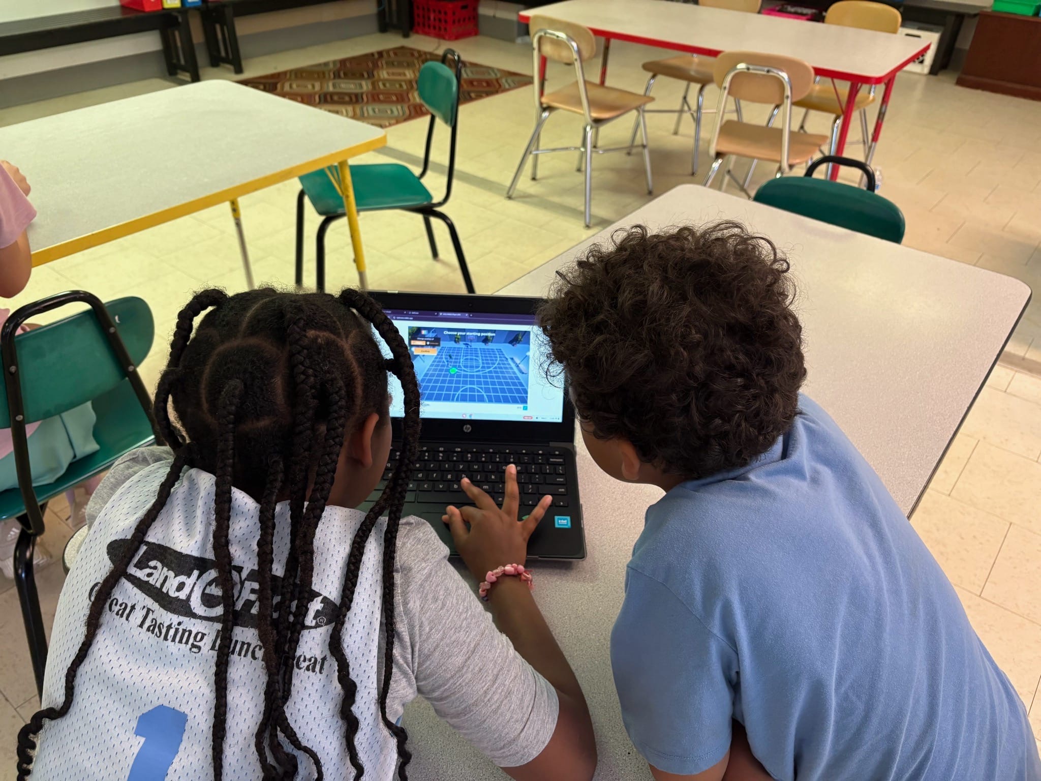 Two kids playing BallCode on computer